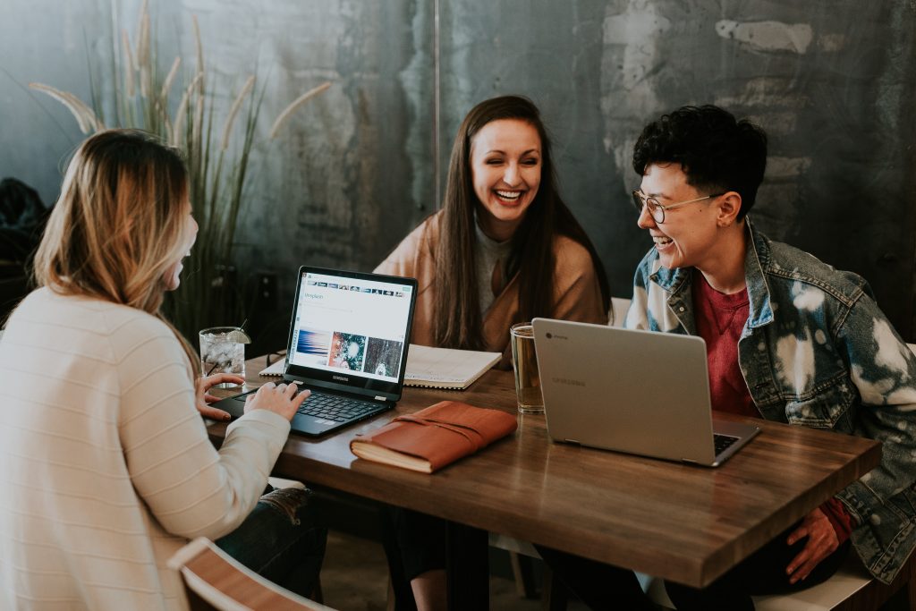 Millennials working at shared desk. Understanding how they harness social media is important in marketing to them.